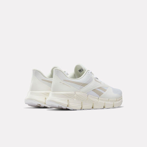 White sneakers with chunky, geometric soles, seen from the back.