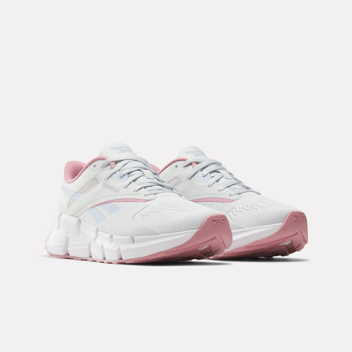 A pair of white running shoes with pink soles and pink interior.
