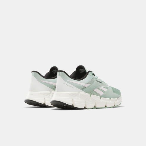 A pair of light green athletic shoes with white accents and a black sole.