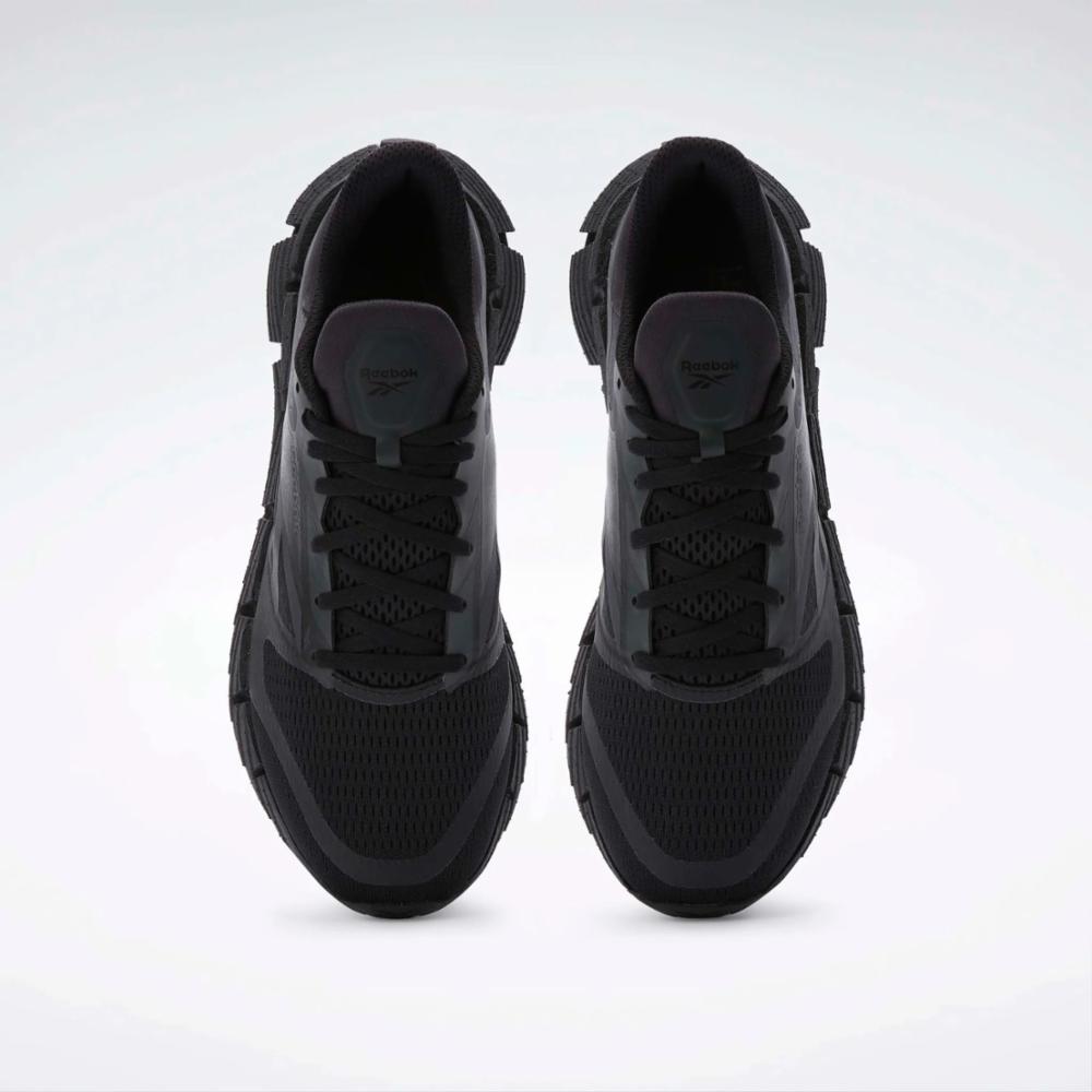 Overhead view of a pair of all-black athletic shoes with laced closure and zig-zag soles.