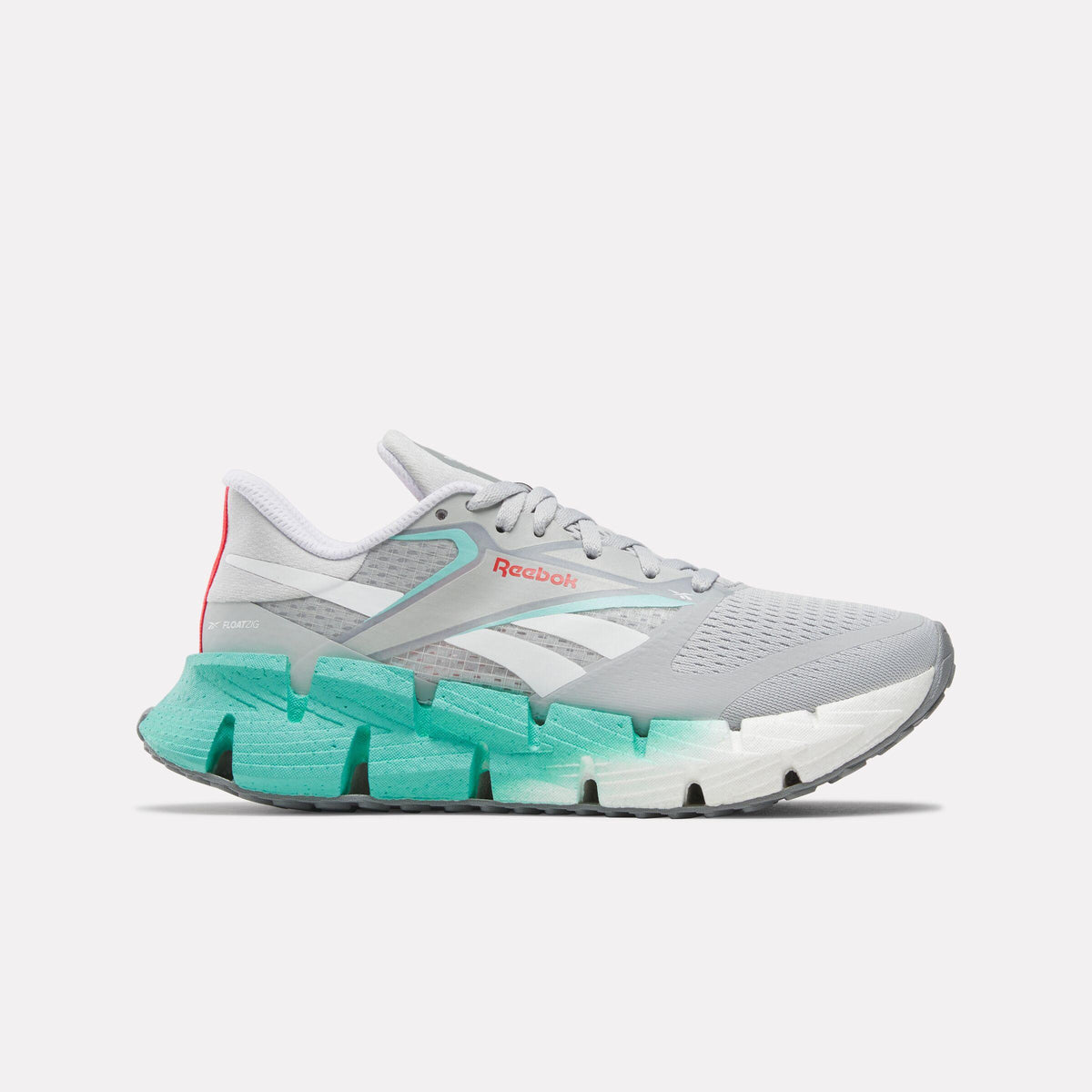 Side view of a light gray running shoe with a blue and white jagged sole and a white logo.