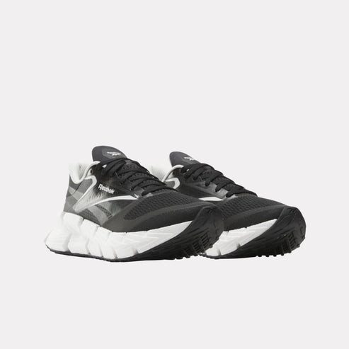 Pair of black and white athletic shoes with laces.