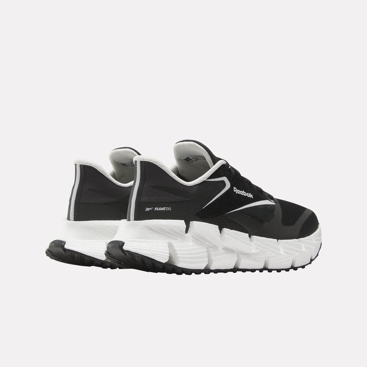 A pair of black and white sneakers with white soles.