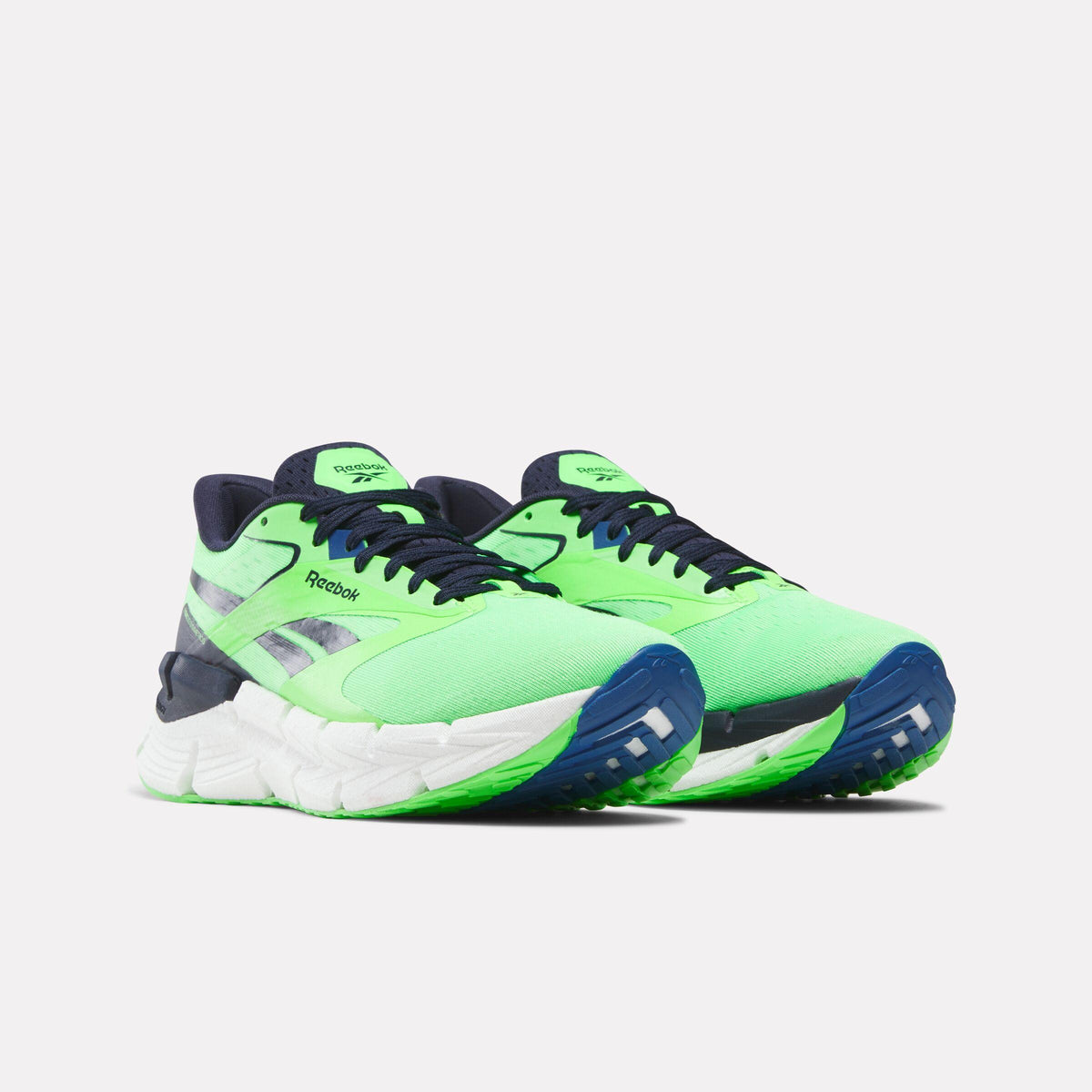 Pair of lime green and navy running shoes with white soles and reflective accents.
