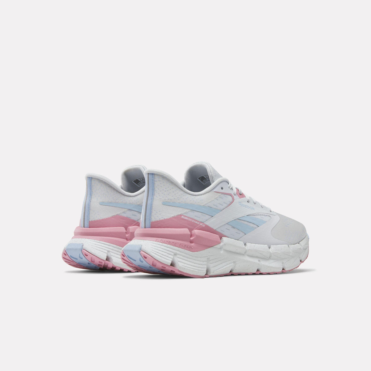 Pair of white sneakers with pink and blue accents, showing the back of the shoes with distinctive segmented soles.