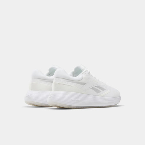 White athletic shoes with low profile, thick ridged soles and a side logo.