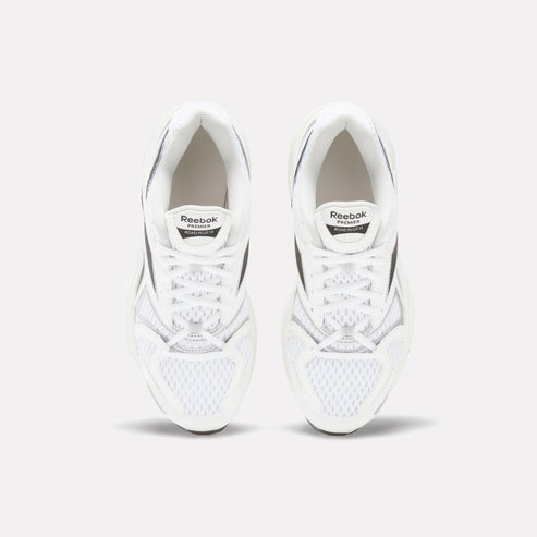 Pair of white sneakers with black accents, laces, and "Reebok" tag.