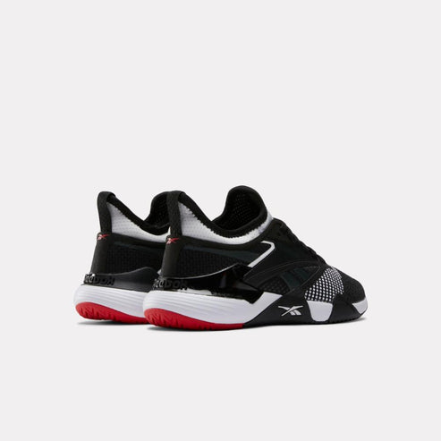 A pair of black and white athletic shoes with red soles.