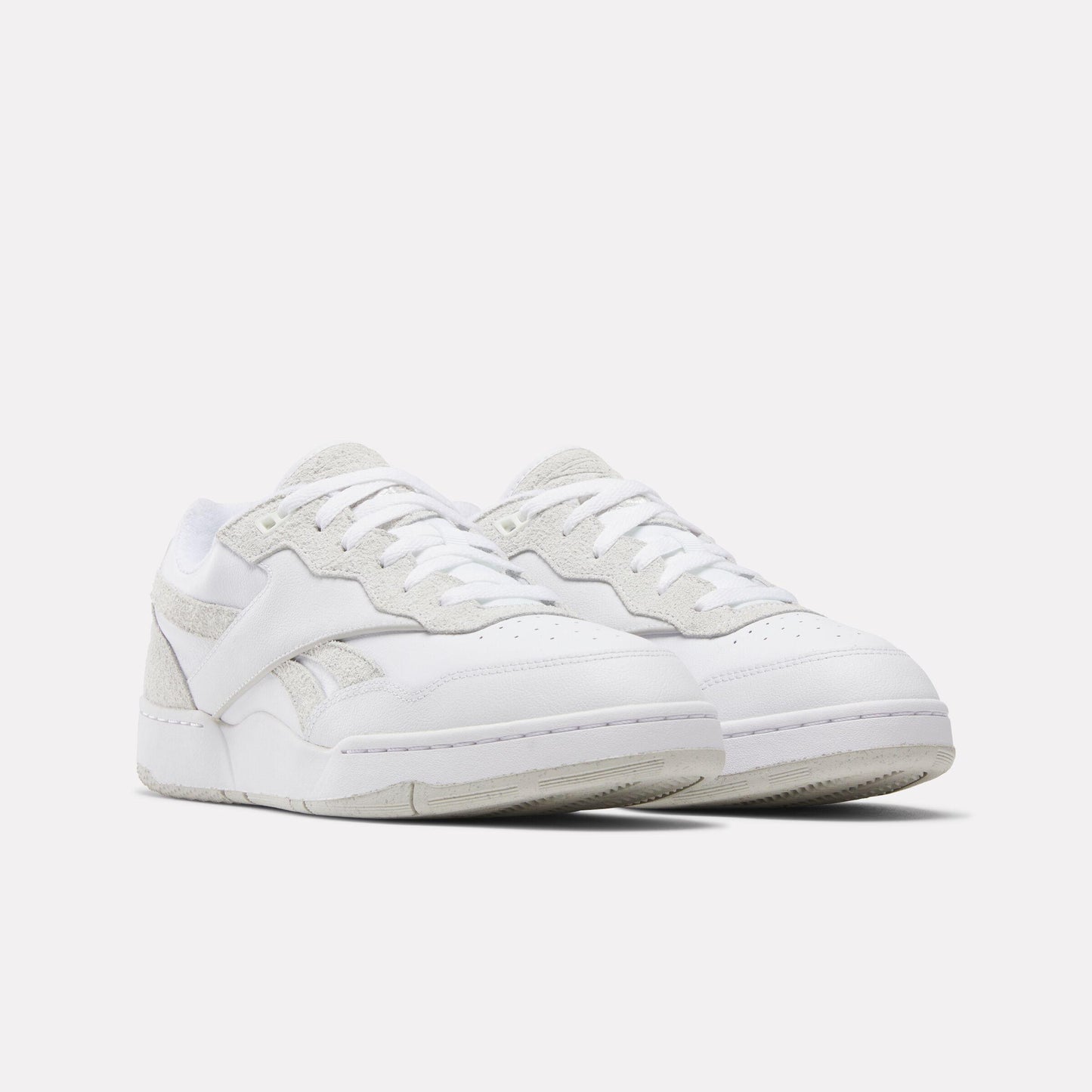 Pair of white low-top sneakers with a leather upper and suede accents.