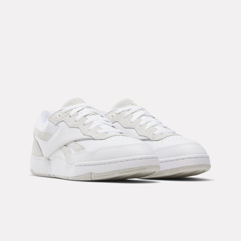 Pair of white low-top sneakers with a leather upper and suede accents.