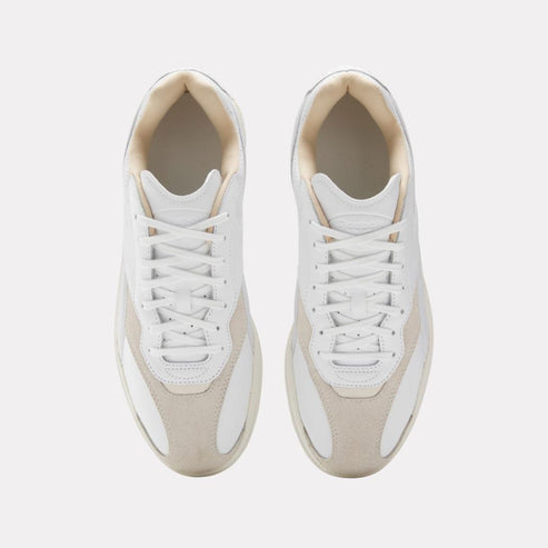 Pair of white sneakers with off-white suede toe and heel.