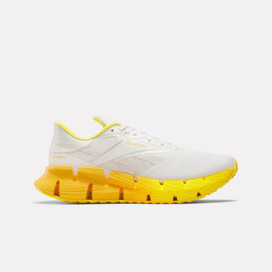 White sneaker with yellow zigzag sole.