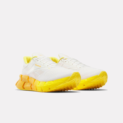 Pair of white and yellow running shoes.