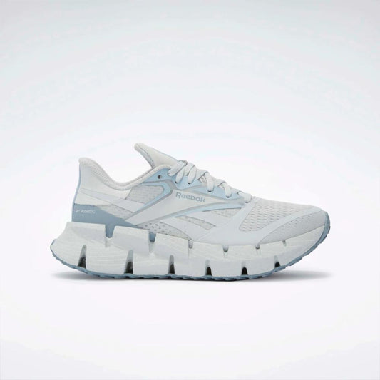 White running shoe with a zigzag patterned sole.