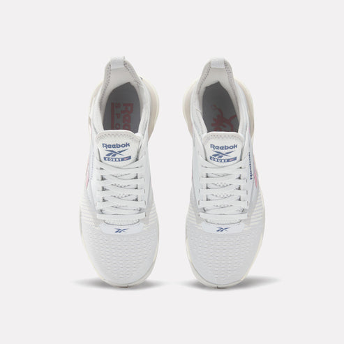 Pair of white athletic shoes, seen from above, with white laces, “Reebok” and an abstract logo visible on the tongue.