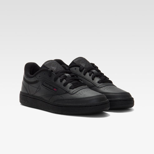 Pair of matte black, leather sneakers with black laces and a thin red stripe detail.