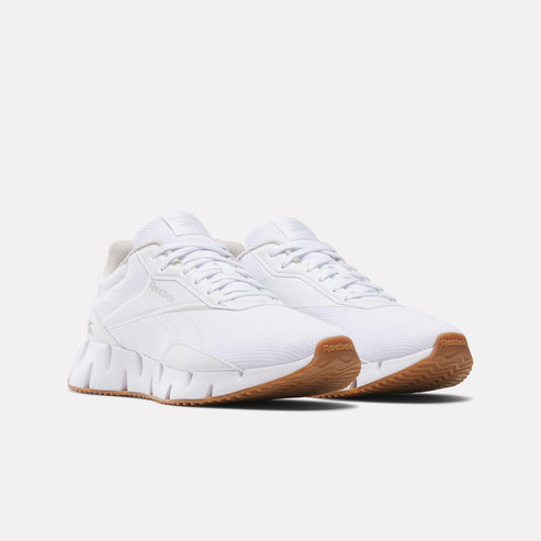Two white sneakers with a gum sole.