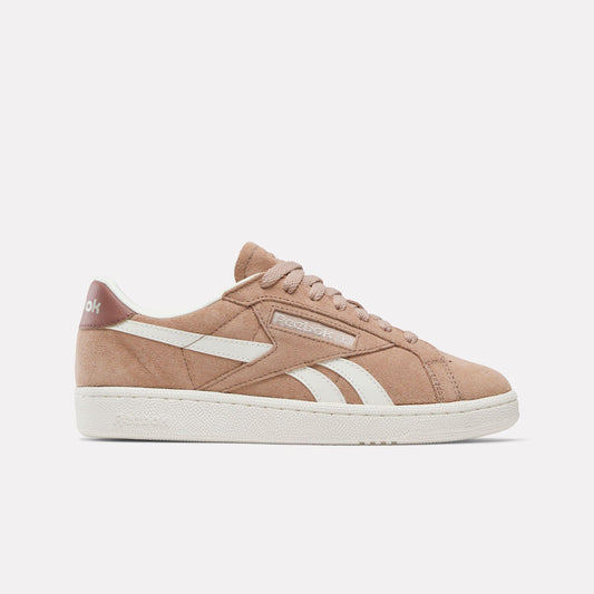 Tan leather sneaker with white sole and stripe, and laces.