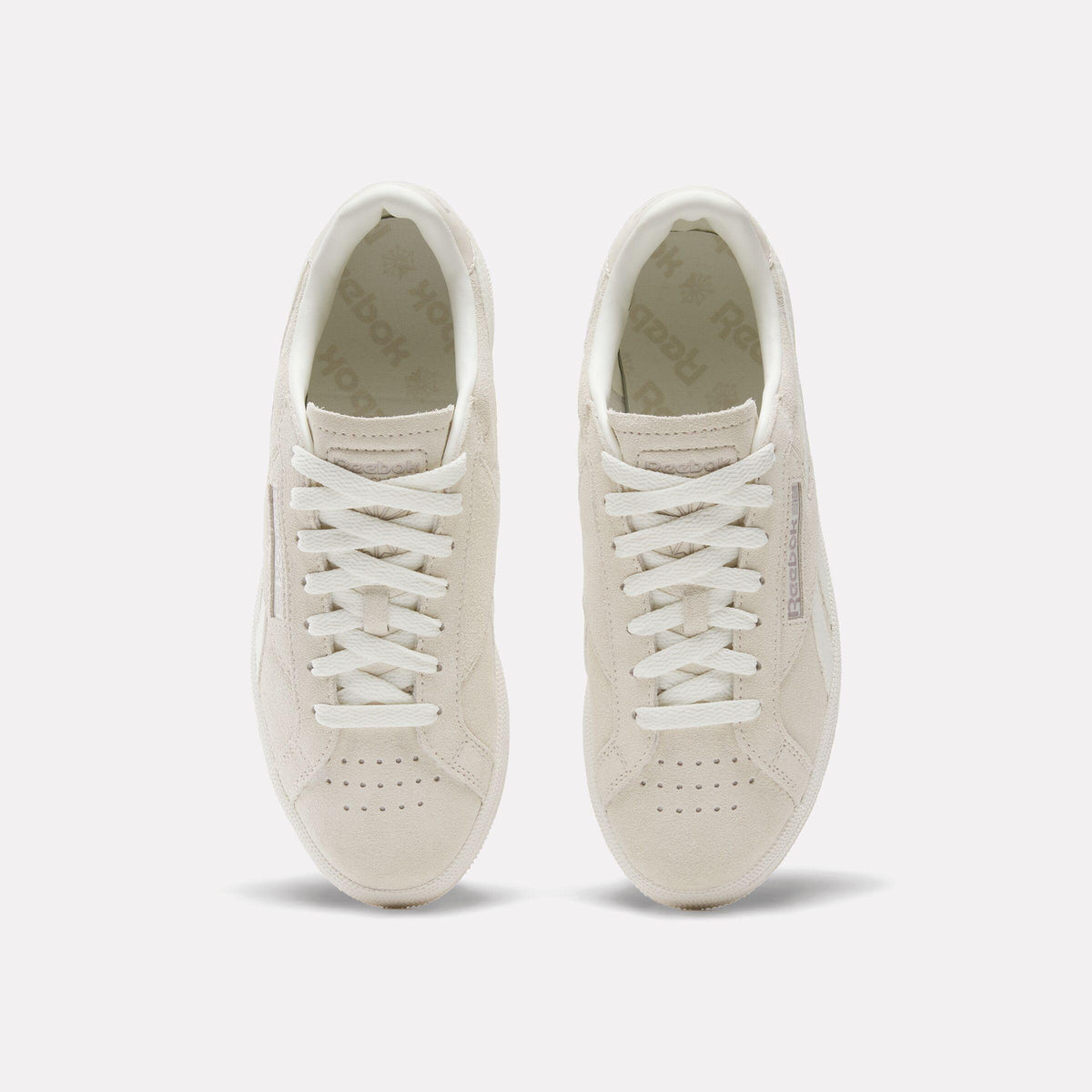 Overhead view of two off-white sneakers with white laces.