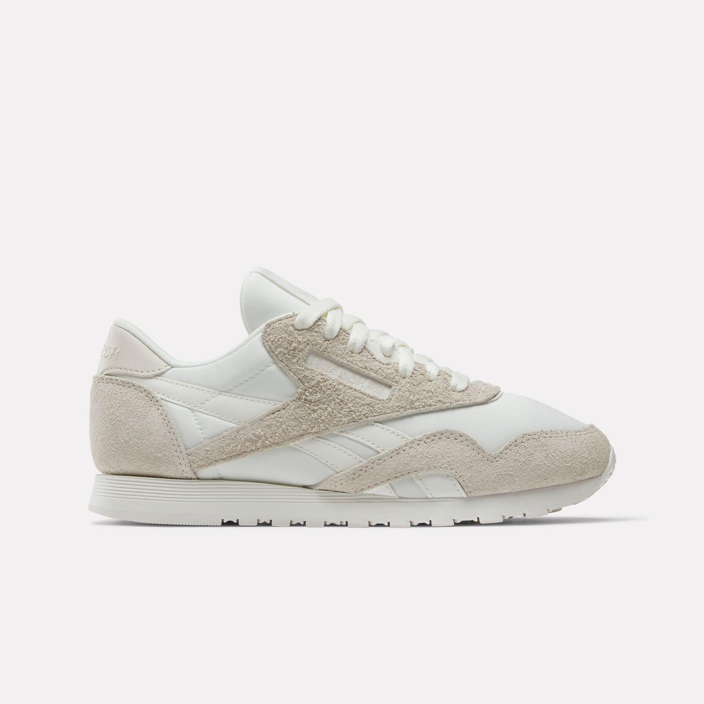 Off-white sneaker with textured suede overlays and off-white laces.