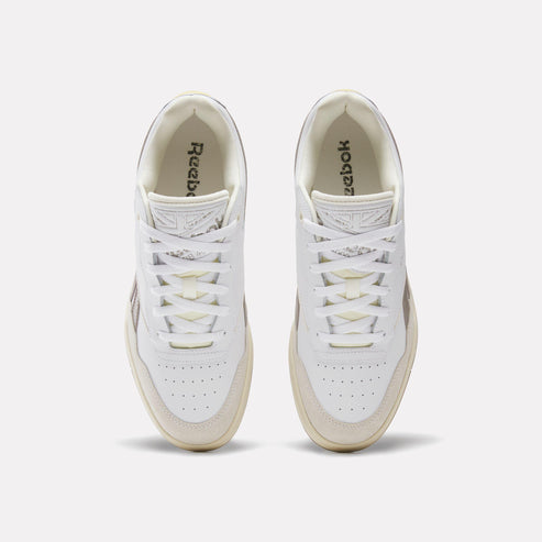 Overhead view of a pair of white leather sneakers with "Reebok" printed on the insole.