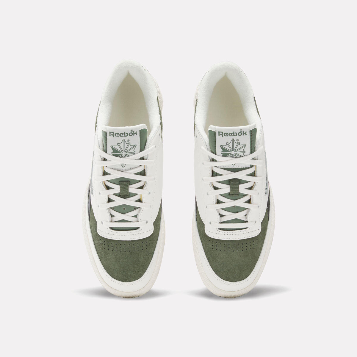 Overhead view of off-white and olive green sneakers with laces.