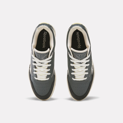 Overhead view of dark gray sneakers with white laces and "Reebok" branding on the tongue.