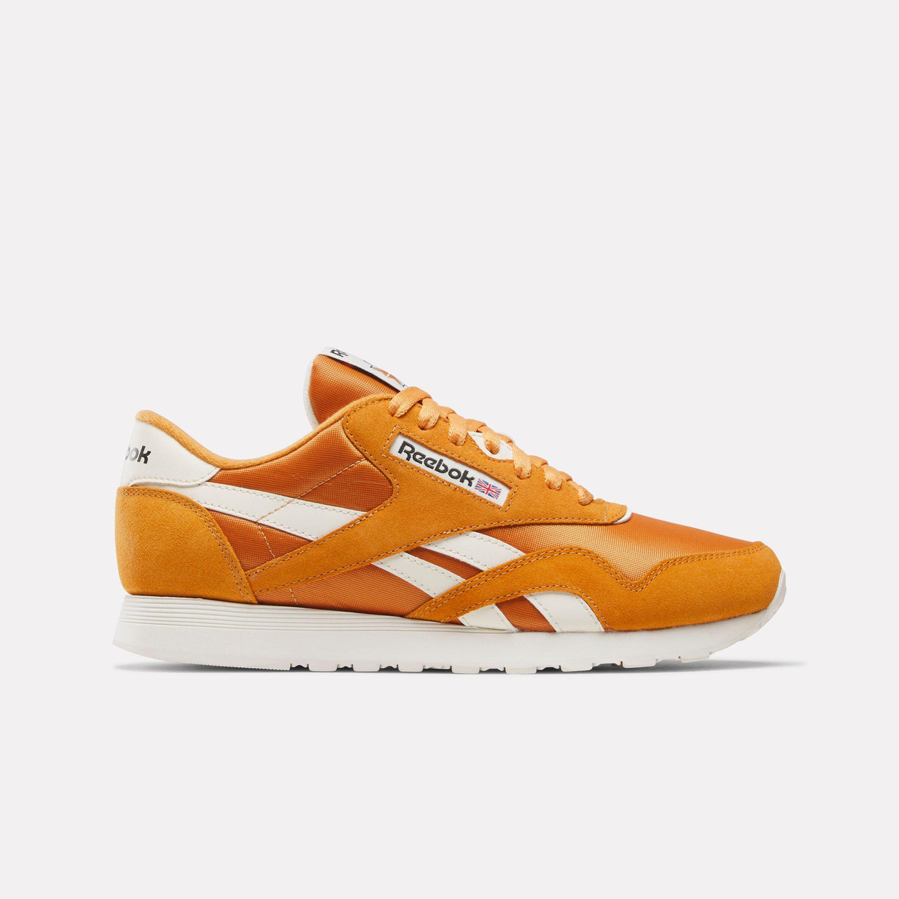 Orange sneaker with white stripes and soles. Text "Reebok" on the side.