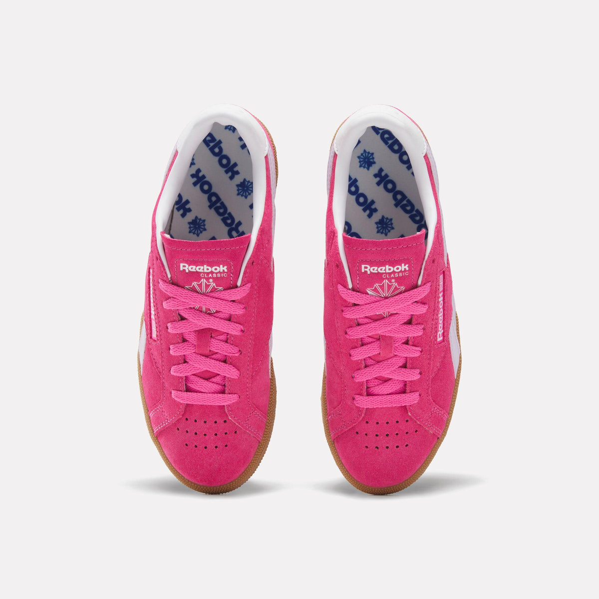 A pair of pink Reebok Classic Club MEMT sneakers with white laces and gum soles.