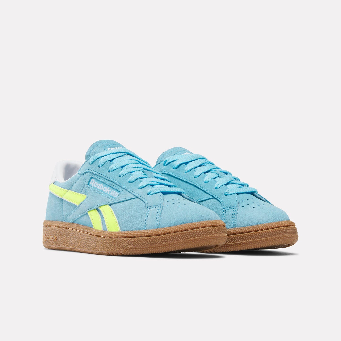 Pair of light blue sneakers with yellow stripes and brown soles.