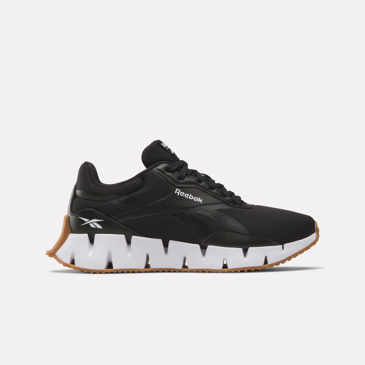 A running shoe is black with a white and brown sole; "Reebok" is visible on the side.