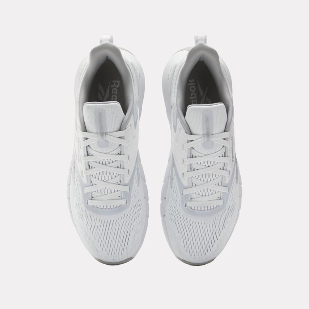 Top view of a pair of white sneakers with white laces.