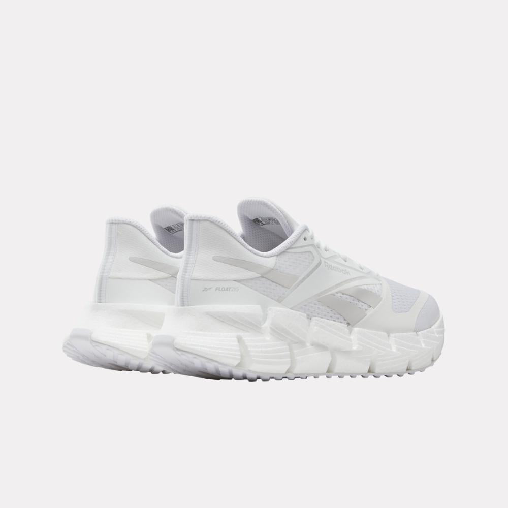 White athletic sneakers with visible logo on side and futuristic sole design, viewed from the rear.