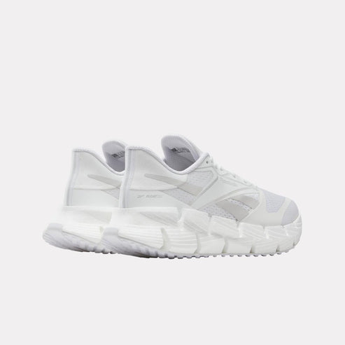 White athletic sneakers with visible logo on side and futuristic sole design, viewed from the rear.