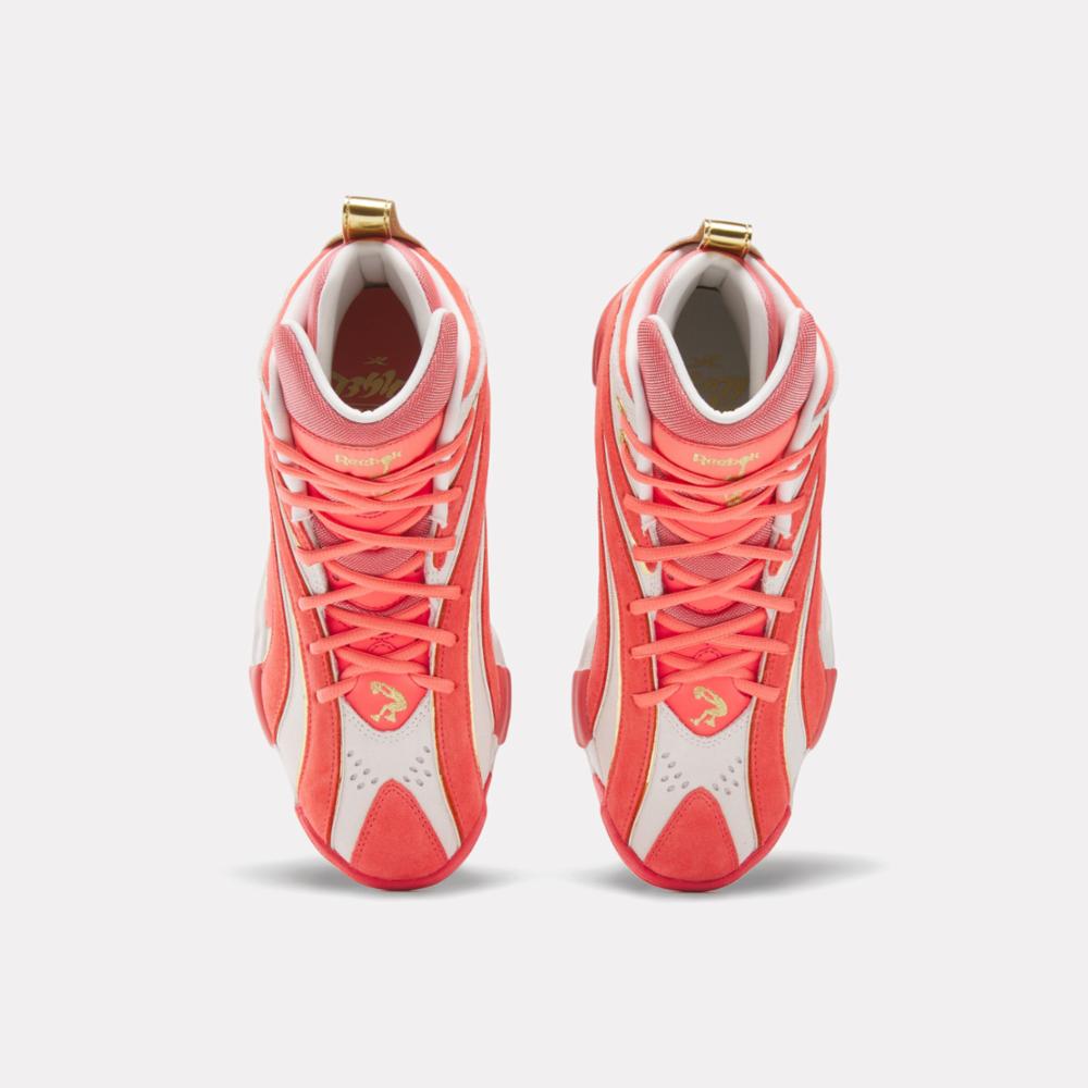 Top-down view of high-top sneakers in a coral and white color scheme with coral laces.