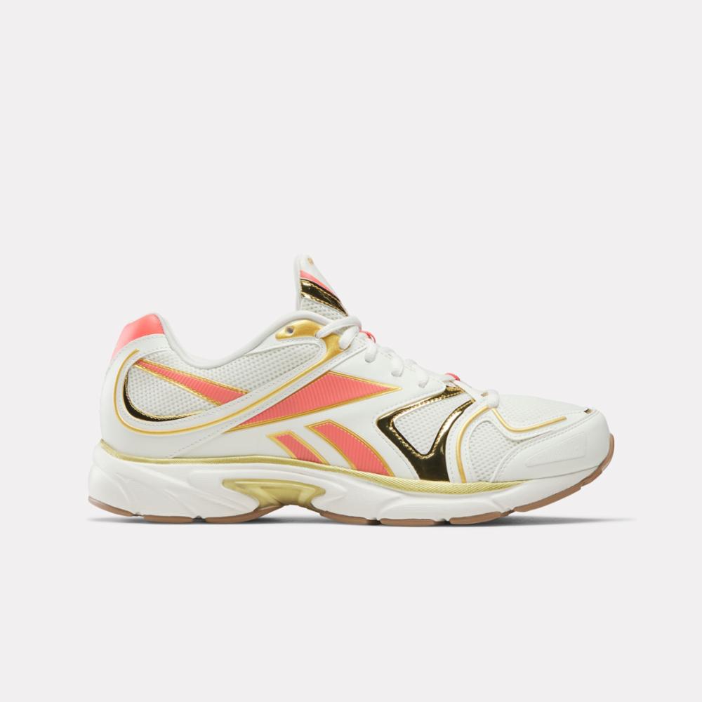 Low-top running shoe in white with gold and coral accents.