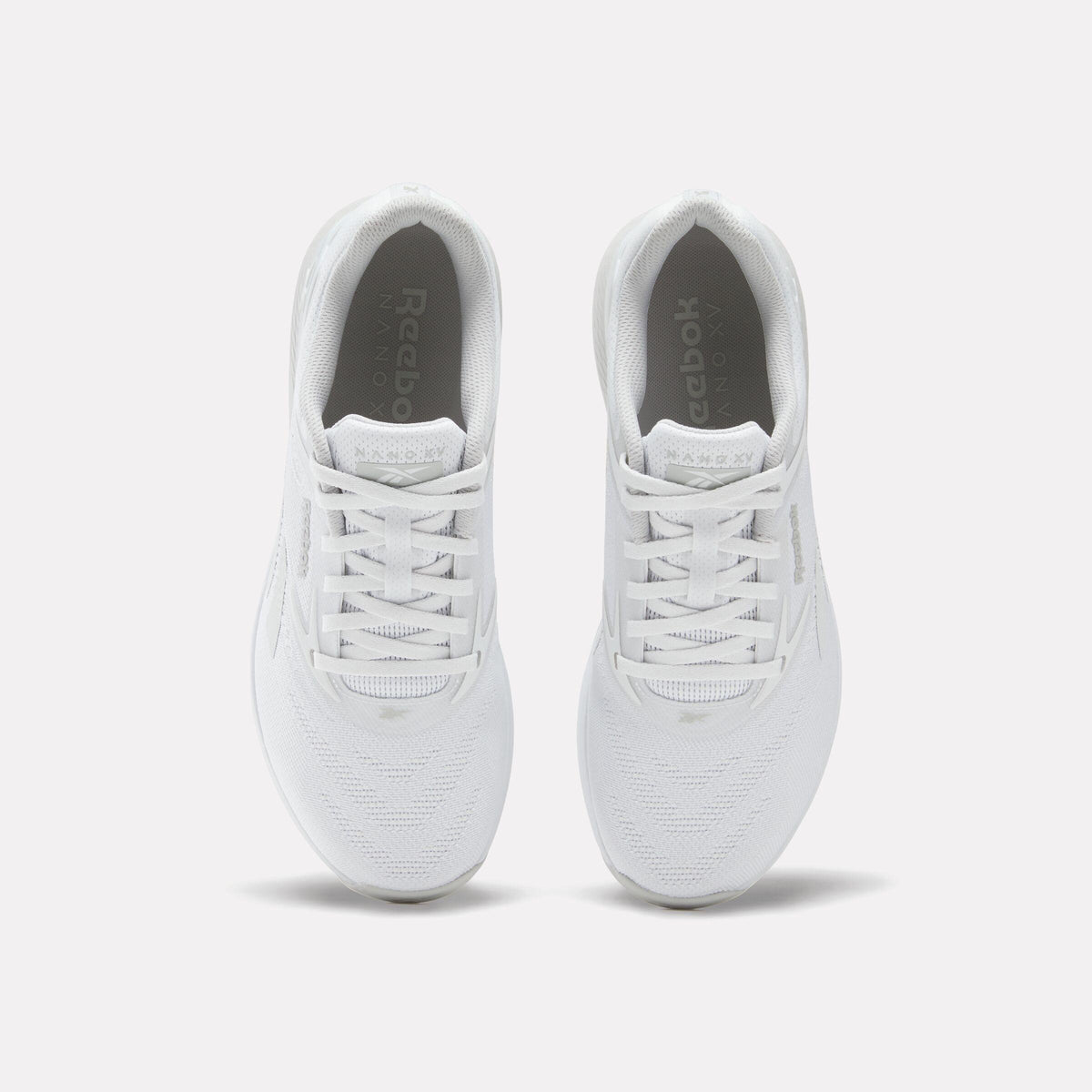 Top view of a pair of white running shoes with white laces.