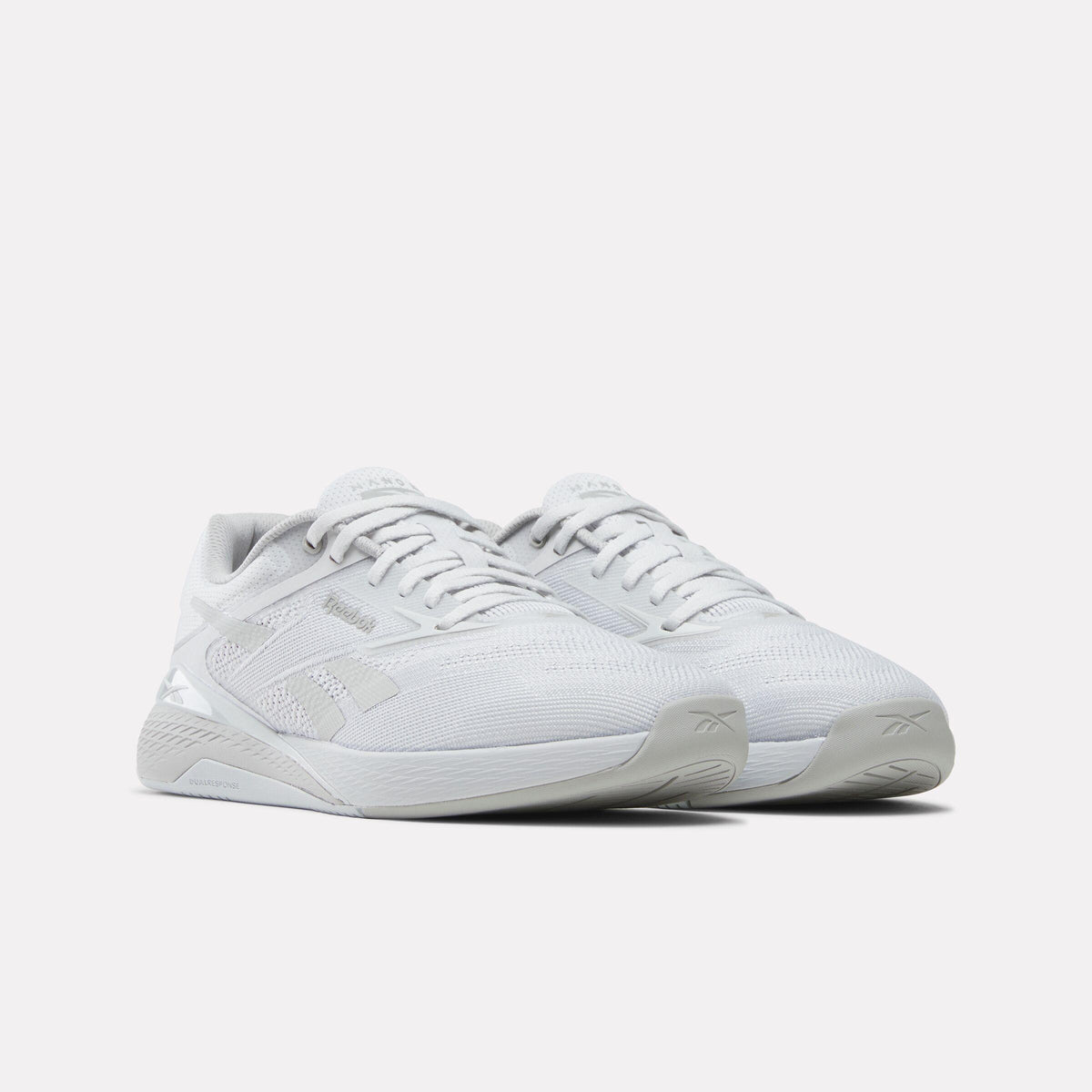 Two light gray athletic shoes with laces.