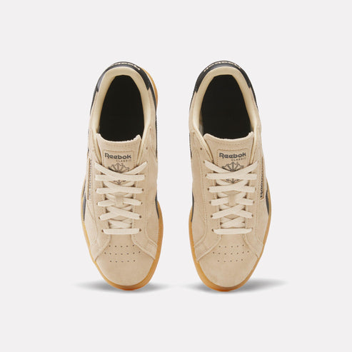 Top-down view of two light brown tennis shoes with light brown rubber soles and white laces.