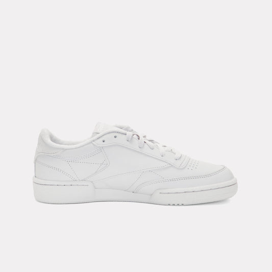 Low-profile white leather sneaker with textured sole and lace-up closure.