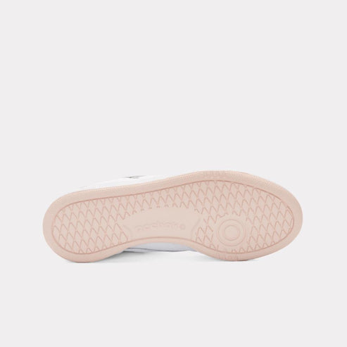 The sole of a white shoe has a pink textured surface with a circular design.