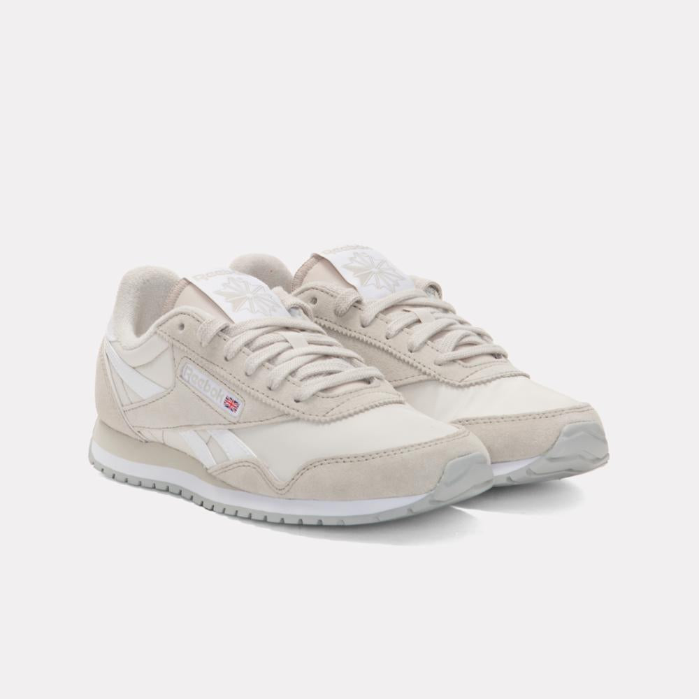 Pair of light beige running shoes with light gray soles and side stripes.