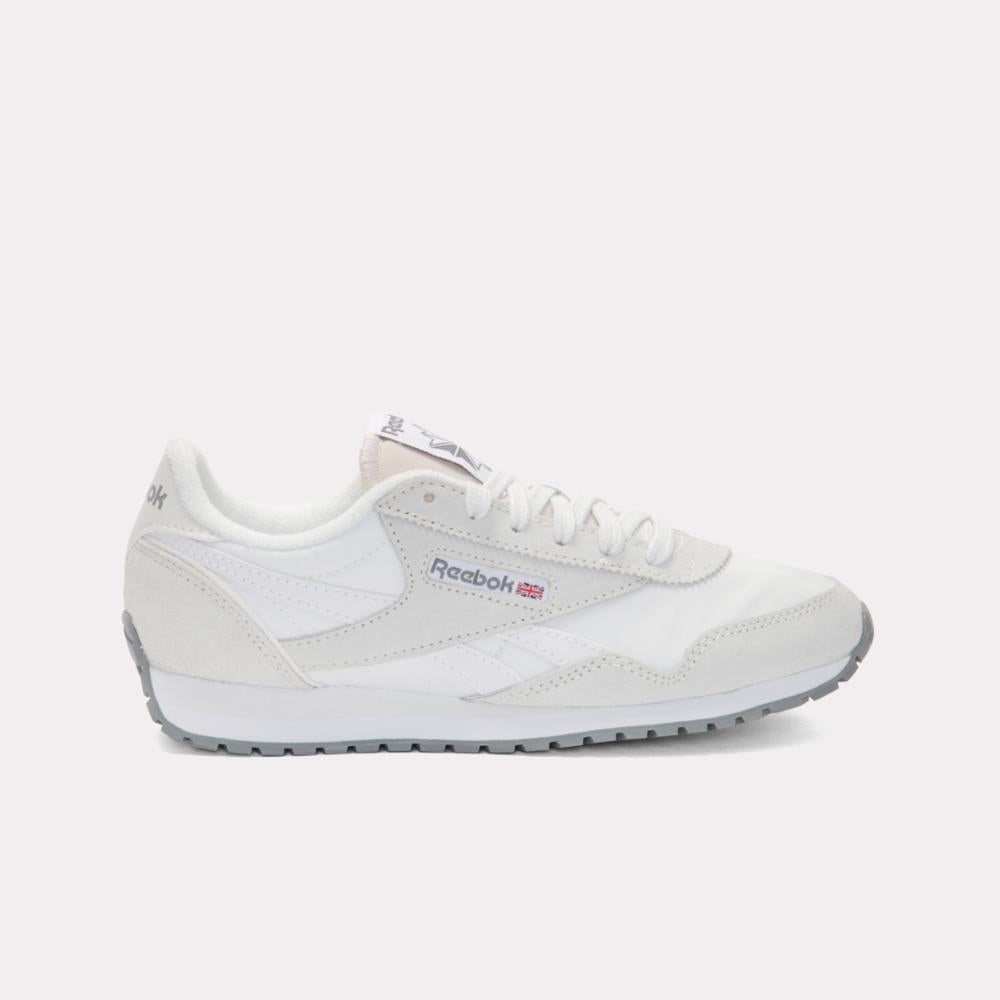 A white running shoe with grey sole and red and blue logo.