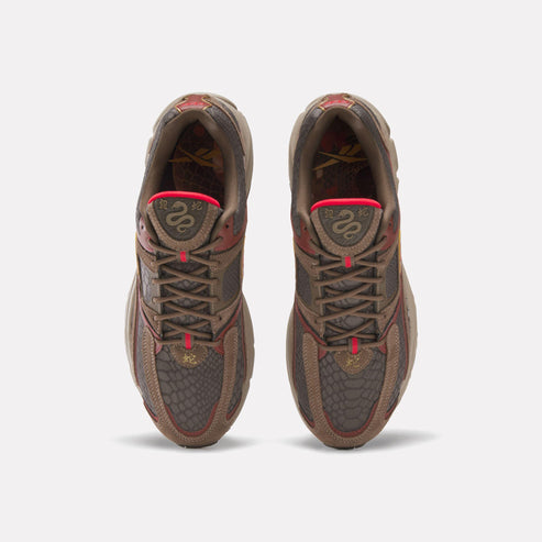Overhead view of brown sneakers with snake design on tongue and toe.