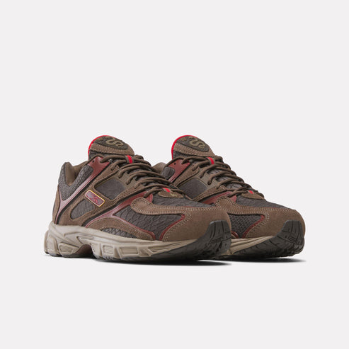 Pair of brown athletic shoes with red trim.