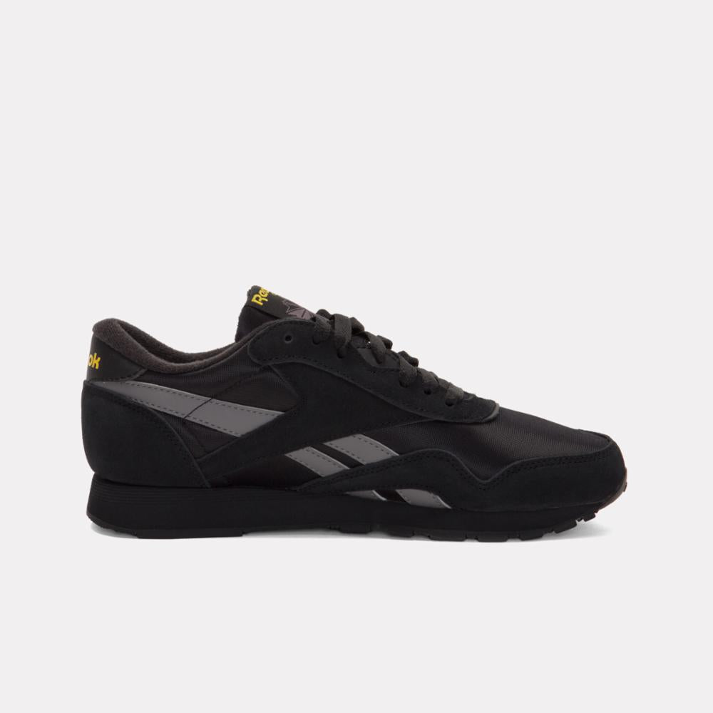 Black sneaker with gray details and gold accents.