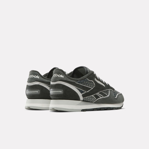 A pair of gray running shoes with white laces, sole, and design.