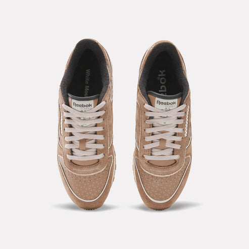 Top-down view of tan suede sneakers with white laces and trim.
