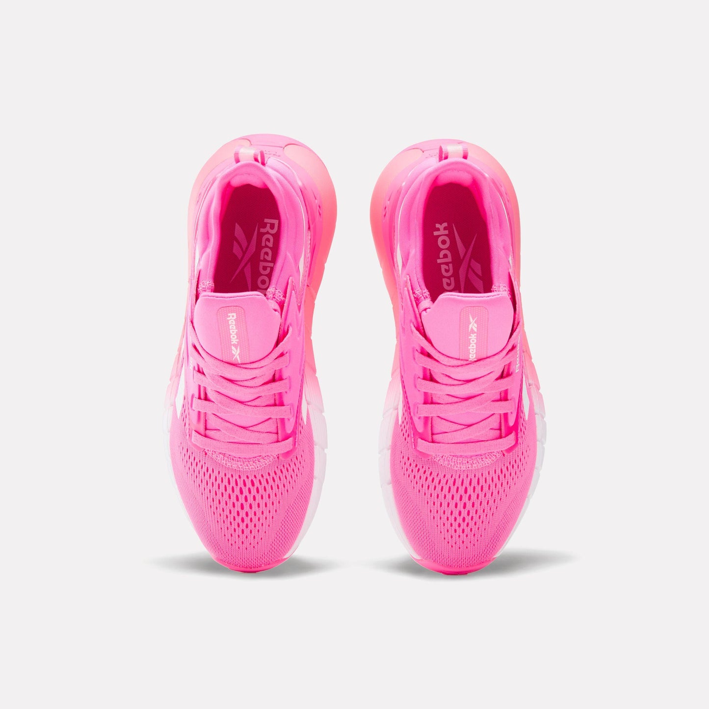 A pair of pink running shoes with pink laces, seen from above.
