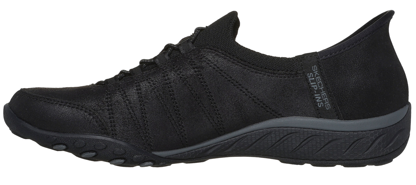 A black slip-on shoe with a low profile and a textured sole.